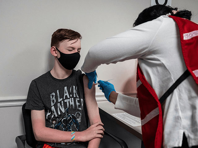 Luke Allan, 13, closes his eyes as he gets a Covid-19 vaccination at the Fairfax Government Center vaccination clinic in Fairfax, Virginia on May 13, 2021. (Andrew Caballero-Reynolds/AFP via Getty Images)