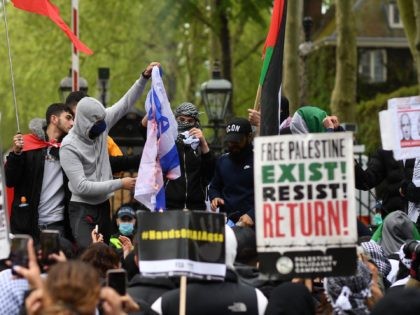 Pro-Palestinian activists and supporters burn an Israeli flag as they demonstrate in support of the Palestinian cause outside the Israeli Embassy in central London on May 22, 2021. (Photo by JUSTIN TALLIS / AFP) (Photo by JUSTIN TALLIS/AFP via Getty Images)