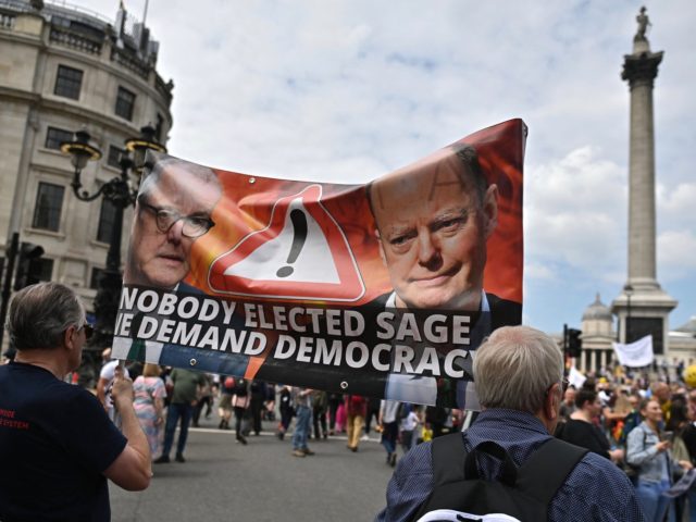 Protestors carry a large banner during a 'Unite For Freedom' march against Covid-19 vaccinations and government lockdown restrictions, in Trafalgar Square, central London on May 29, 2021. (Photo by Ben STANSALL / AFP) (Photo by BEN STANSALL/AFP via Getty Images)