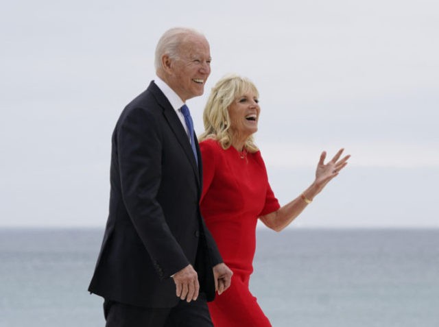 US President Joe Biden and US First Lady Jill Biden walk along the boardwalk at the start