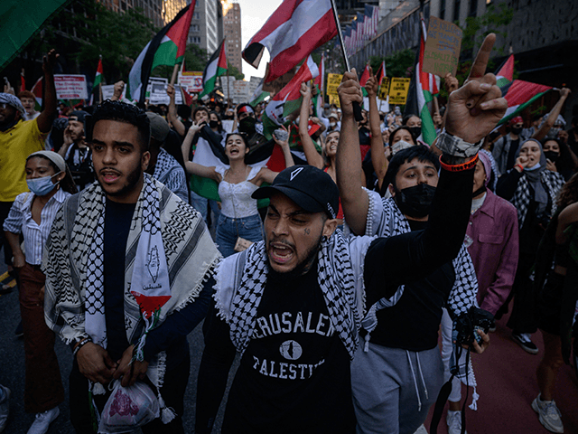 Demonstrators shout slogans and wave flags as they march during an 'emergency rally to defend Palestine' in Manhattan, New York on June 15, 2021. - Israel carried out air strikes on the Gaza Strip early June 16 after militants in the Palestinian territory sent incendiary balloons into the south of the country, in the first flare-up between the two sides since a major conflict in May in which hundreds were killed. (Photo by Ed JONES / AFP) (Photo by ED JONES/AFP via Getty Images)