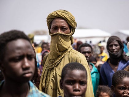 TOPSHOT - Refugees stand in Goudebou, a camp that welcomes more than 11,000 Malian refugees in northern Burkina Faso, on International Refugee Day on June 20, 2021. - Oscar-winning actor Angelina Jolie on Sunday visited a refugee camp in Burkina Faso sheltering thousands of Malians who have fled jihadist violence …
