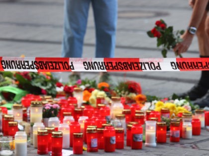 27 June 2021, Bavaria, Würzburg: Flowers are laid outside a cordoned-off department store where a man had attacked people with a knife. In the attack on 25.06.2021, a Somali man had killed three women in a department store. On the street and in a nearby bank he injured afterwards according …