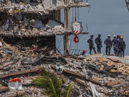 TOPSHOT - Search and Rescue teams look for possible survivors in the partially collapsed 12-story Champlain Towers South condo building on June 27, 2021 in Surfside, Florida. - The death toll after the collapse of a Florida apartment tower has risen to nine, the local mayor said on June 27, …