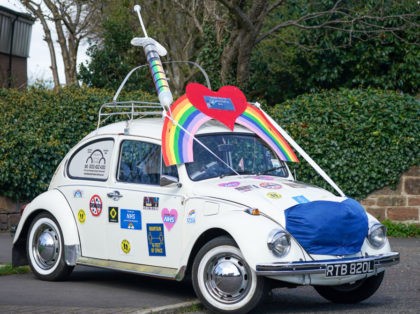 WEST KIRBY, UNITED KINGDOM- MARCH 29: A classic Volkswagen Beetle is decorated in tribute to the NHS with social distance slogans, a mask and a giant vaccine hypodermic needle on March 29, 2021 in West Kirby, United Kingdom. Today the government eased its rules restricting outdoor socialising and sport in …