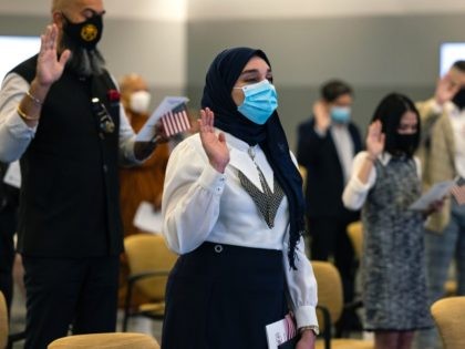 CAMP SPRINGS, MARYLAND - MAY 27: New U.S. Citizens take their Oath of Allegiance during a naturalization ceremony at the United States Citizenship and Immigration Services (USCIS) Headquarters on May 27, 2021 in Camp Springs, Maryland. This special Naturalization Ceremony honored Asian American Pacific Islanders and was the first ceremony …