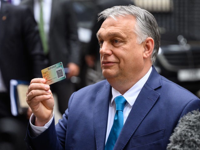 LONDON, ENGLAND - MAY 28: Hungarian Prime Minister Viktor Orbán holds up his COVID-19 vaccination card after a meeting with UK Prime Minister Boris Johnson at Downing Street on May 28, 2021 in London, England. Hungarian Prime Minister Viktor Orbán is the second EU leader to be welcomed to Downing …