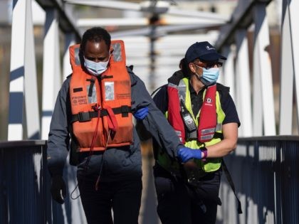 DOVER, ENGLAND - JUNE 09: Border Force officials guide newly arrived migrants to a holding facility after being picked up in a dinghy in the English Channel on June 09, 2021 in Dover, England. More than 500 migrants arrived in the final week of May, according to the UK Home …