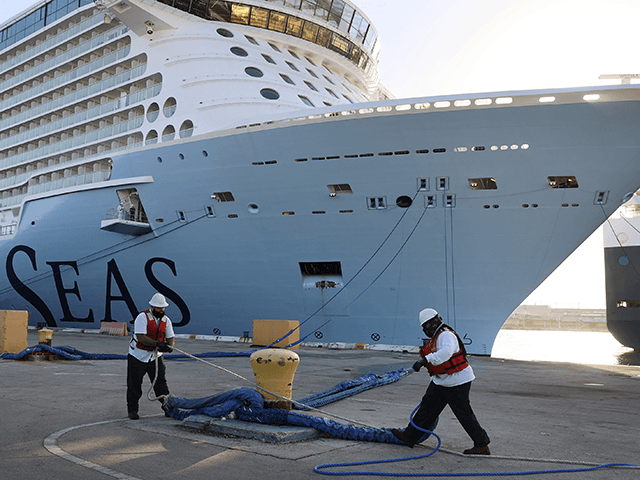Dock workers use ropes to tie the Royal Caribbean’s Odyssey of The Seas to its berthing spot at Port Everglades on June 10, 2021 in Fort Lauderdale, Florida. The Odyssey of The Seas will hold its first passenger cruise on July 3rd through the Caribbean. The ship was scheduled to …