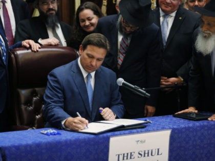 SURFSIDE, FLORIDA - JUNE 14: Florida Gov. Ron DeSantis signs two bills at the Shul of Bal Harbour on June 14, 2021 in Surfside, Florida. The bills are HB 529 and HB 805. HB 805 ensures that volunteer ambulance services, including Hatzalah, can operate. HB 529 requires Florida schools to …