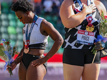 Gwendolyn Berry (L), third place, turns away from U.S. flag during the U.S. National Anthem as DeAnna Price (C), first place, also stands on the podium after the Women's Hammer Throw final on day nine of the 2020 U.S. Olympic Track & Field Team Trials at Hayward Field on June …