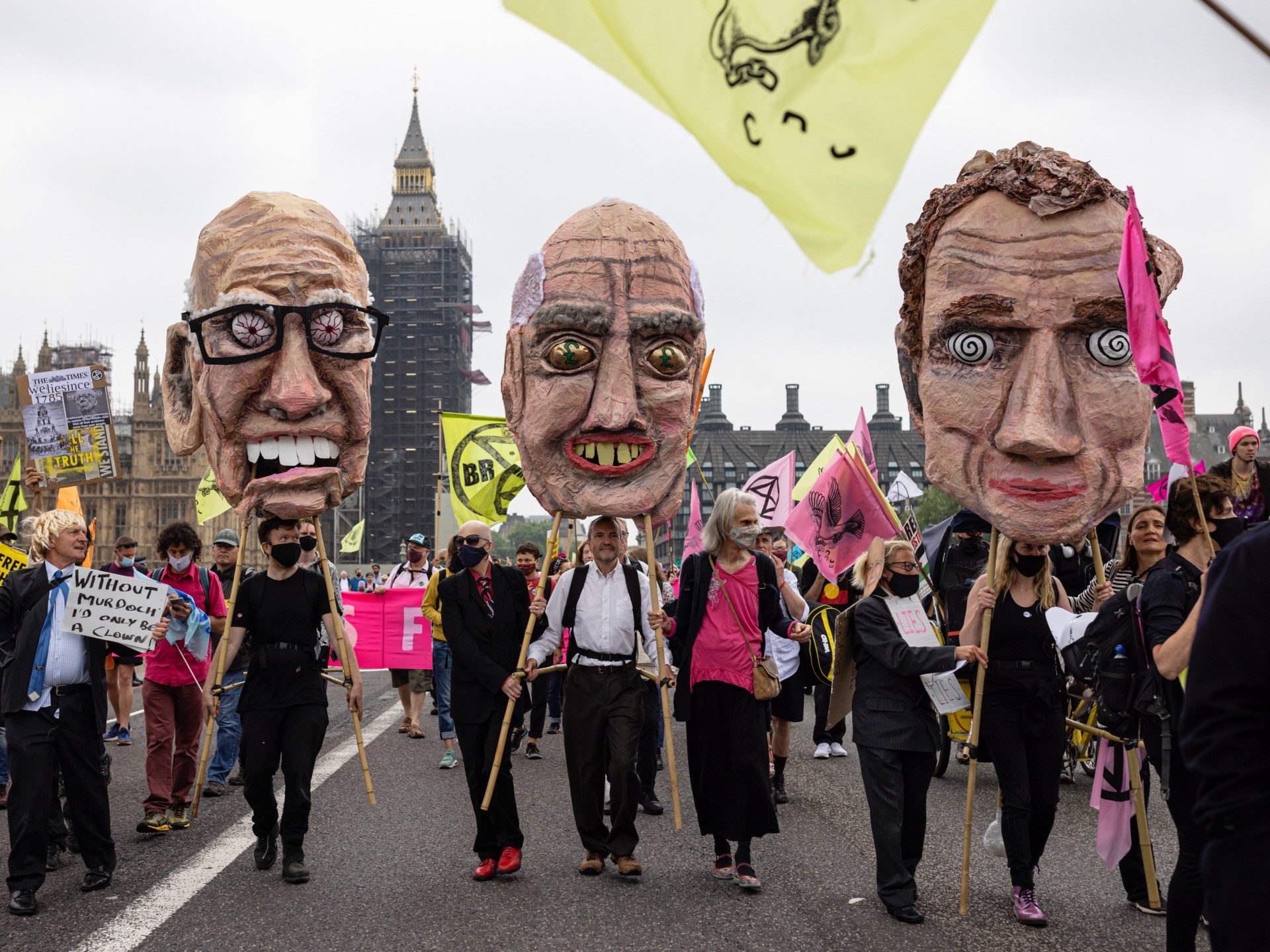 LONDON, ENGLAND - JUNE 27: Extinction Rebellion protesters carry papier mache heads of media business owners across Westminster Bridge during a protest on June 27, 2021 in London, England. Climate Change action group Extinction Rebellion protest at the perceived control of the UK Media by just four billionaires. (Photo by Rob Pinney/Getty Images)