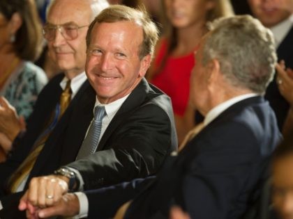Chairman of Points of Light Neil Bush (C) shakes hands with his father, former US President George H.W. Bush, while attending a White House ceremony to recognize the Points of Light volunteer program in Washington, DC, July 15, 2013. President Obama and First Lady Michelle Obama hosted former President George …