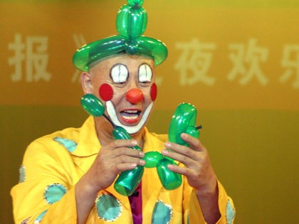 BEJING, CHINA - OCTOBER 9: A clown makes a balloon dog for a girl during a performance of the national "Star Circus" October 9, 2003 in Beijing, China. The circus performs in Beijing for national holidays. (Photo by Getty Images)