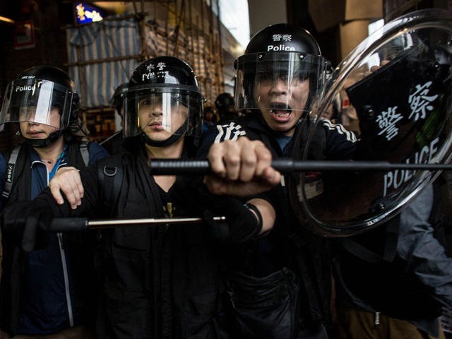 HONG KONG - DECEMBER 01: Police advance on pro-democracy protesters at the Admiralty MTR station on December 1, 2014 in Hong Kong. Leaders from the Federation of Students called on fellow protesters to attend a rally and come prepared for escalated action. Protesters were asked to bring masks, umbrellas and …