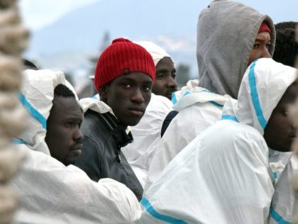 Men wait to disembark from the Italian Coast Guard vessel "Dattilo" following a