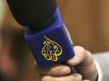 A reporter from the Arabic television channel Al-Jazeera holds a microphone during an inte