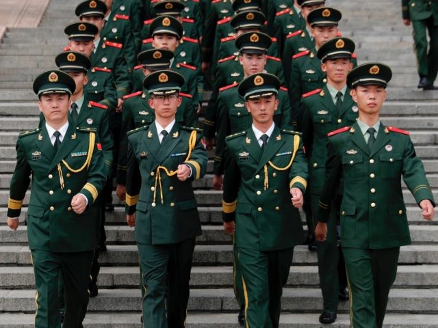TOPSHOT - Chinese paramilitary policemen march outside the Great Hall of the People after