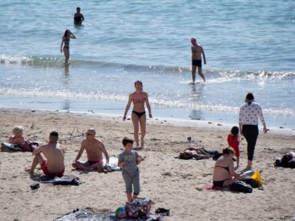 People sunbathe and swim at the Catalans beach (Plage des Catalans) in Marseille, southern