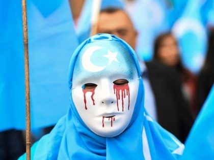 TOPSHOT - A person wearing a white mask with tears of blood takes part in a protest march of ethnic Uighurs asking for the European Union to call upon China to respect human rights in the Chinese Xinjiang region and ask for the closure of "re-education center" where Uighurs are …