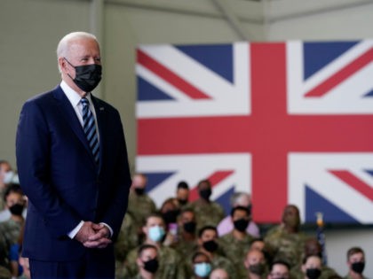 President Joe Biden listens as first lady Jill Biden speaks to American service members at