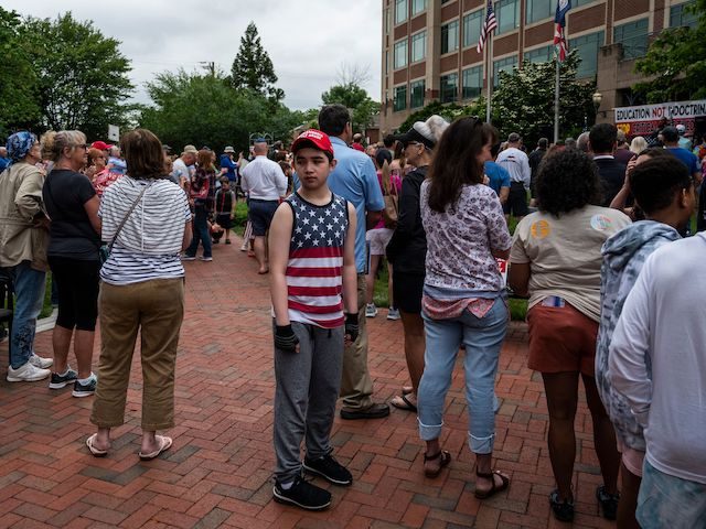 A young boy walks through the crowd during a rally against "critical race theory" (CRT) being taught in schools at the Loudoun County Government center in Leesburg, Virginia on June 12, 2021. - "Are you ready to take back our schools?" Republican activist Patti Menders shouted at a rally opposing …
