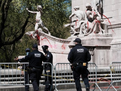 NEW YORK, NEW YORK - APRIL 23: Police stand by as a city worker cleans graffiti from the USS Maine National Monument following a night of protests on April 23, 2021 in New York City. Six protesters were arrested Thursday night as they scuffled with police near the USS Maine …