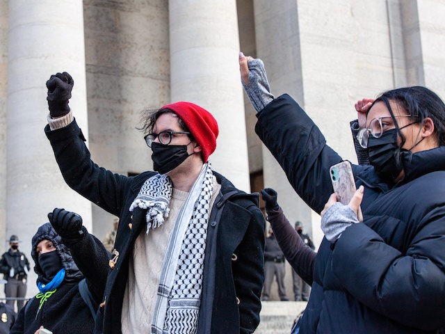 COLUMBUS, OHIO, UNITED STATES - 2021/01/20: Demonstrators hold their fists high in front of the Ohio Statehouse. Activist groups in Columbus came together to form the 'United Front Against the Far-Right and Capitalist System!' This demonstration began at Columbus City Hall, marched to the Columbus Statehouse and concluded with a …
