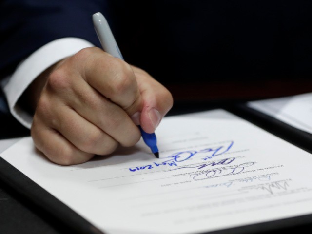 Florida Gov. Ron DeSantis signs a bill during a signing ceremony at the William J. Kirlew Junior Academy, Thursday, May 9, 2019, in Miami Gardens, Fla. The bill creates a new voucher program for thousands of students to attend private and religious schools using taxpayer dollars traditionally spent on public schools.(AP Photo/Lynne Sladky)