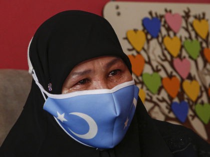 Bumeryem Rozi, 55, an ethnic Uyghur who fled from China to Turkey, cries as she talks to T