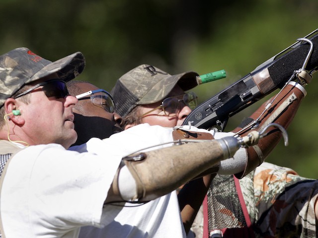 Delvin McMillian, 27, center, of Birmingham, Ala., gets help shooting at clay pigeons with volunteer shooting instructors Frank Dennis, left, and Chris Geiger, right, Friday Sept. 29, 2006 in Jackson's Gap, Ala. Twenty five disabled veterans were in rural east Alabama for Operation Adventure, an outdoor sports program put on by the Birmingham-based Lakeshore Foundation at Camp ASCCA, an Easter Seals camp that draws more than 10,000 disabled children and adults annually to Lake Martin. (AP Photo/Rob Carr )