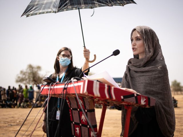 US actress Angelina Jolie, United Nations High Commissioner for Refugees (UNHCR) special envoy, gives a statement in Goudebo, a camp that welcomes more than 11,000 Malian refugees in northern Burkina Faso, on International Refugee Day on June 20, 2021. - Oscar-winning actor Angelina Jolie on Sunday visited a refugee camp …