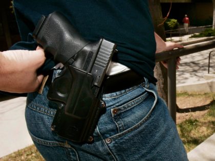 Brent Tenney displays his Glock 9mm semi-automatic handgun on the University of Utah campu