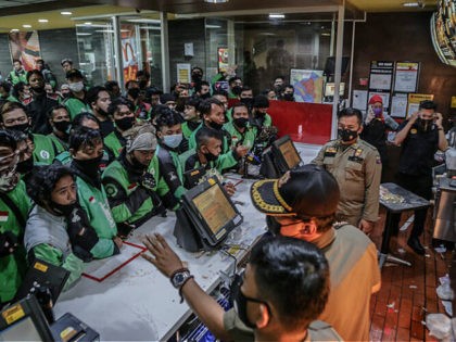 Food delivery riders queue up at a McDonalds outlet in Bogor on June 9, 2021, to buy the new BTS-meal deal for hungry fans in the K-Pop mad country, causing more than a dozen McDonald's outlets to temporarily shuttered over virus fears. (Photo by ADITYA AJI / AFP) (Photo by …