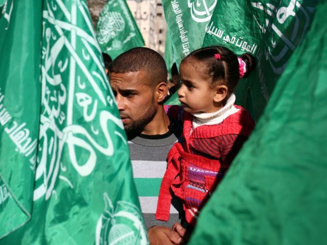Supporters of the Palestinian Hamas movement stand between Hamas movement flags as they at