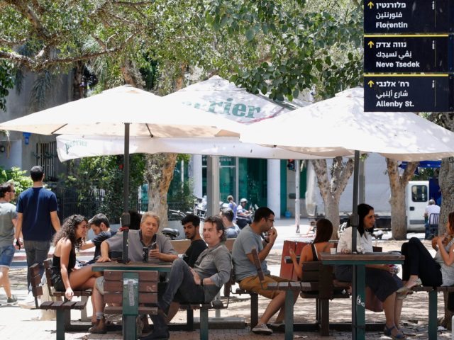 Israelis sit at a coffee shop in Tel Aviv on May 27, 2020 as restaurants were allowed to open for the first time in months after the Israeli government approved the easing of measures put in place to stop the spread of the coronavirus Covid-19. (Photo by JACK GUEZ / …