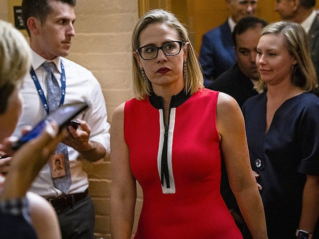 WASHINGTON, DC - JUNE 08: U.S. Sen. Kirsten Sinema (D-AZ) heads back to a bipartisan meeting on infrastructure in the basement of the U.S. Capitol building after the original talks fell through with the White House on June 8, 2021 in Washington, DC. Senate Majority Leader Chuck Schumer (D-NY) said …