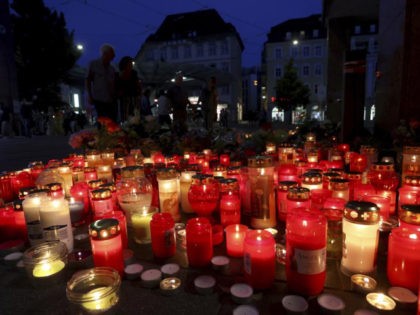 Flowers and candles in front of a closed and cordoned off department store in the city centre of Wuerzburg, Germany, Saturday, June 26, 2021. Authorities say a man armed with a long knife killed several people and injured others, some seriously, in Germany’s southern city of Wuerzburg on Friday before …