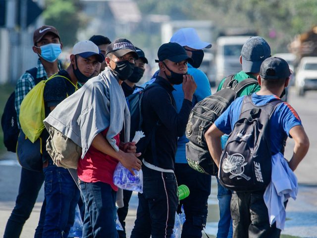Migrants are seen on the border of a road in Puerto Cortes, Honduras on March 30, 2021, as they head in a caravan to Corinto, in the border with Guatemala, on their way to the US. - At least 300 Honduran migrants started a caravan heading to the US in …
