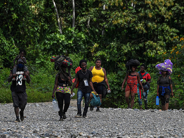 Migrants walk after crossing the Chucunaque river and walking for five days in the Darien Gap, in Bajo Chiquito village, Darien province, Panama on February 10, 2021, on their way to the US. - Migrants from Haiti and several African countries remain stranded at the Panama-Colombia border, while the Central …