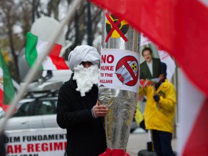 A demonstrator holds a mock-up of a nuclear missile with the lettering 'No nuke to the mullahs' as he protests against Iran's nuclear program and regime in front the Palais Coburg in Vienna on November 22, 2014, where nuclear talks with Iran are to take place. At stake in the …