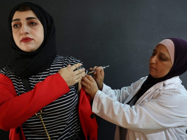 A Palestinian nurse with the ministry of health gives a shot of a Covid-19 vaccine, in a cultural hall in the village of Dura, west of the West Bank town of Hebron, on June 2, 2021. (Photo by HAZEM BADER / AFP) (Photo by HAZEM BADER/AFP via Getty Images)