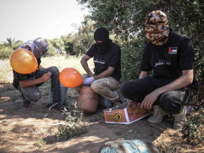 GAZA CITY, GAZA - JUNE 16: Masked Palestinian supporters of the Al-Nasir Salah Al-Din Brigades prepare incendiary balloons to launch across the border fence east of Gaza city towards Israel, on June 16, 2021 east of Gaza City in Gaza. The flare-up came after a controversial flag-waving march by Israeli …