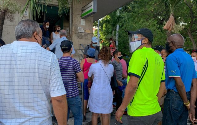 People line up outside a bank branch in Havana on June 11, 2021, to deposit US dollars bef