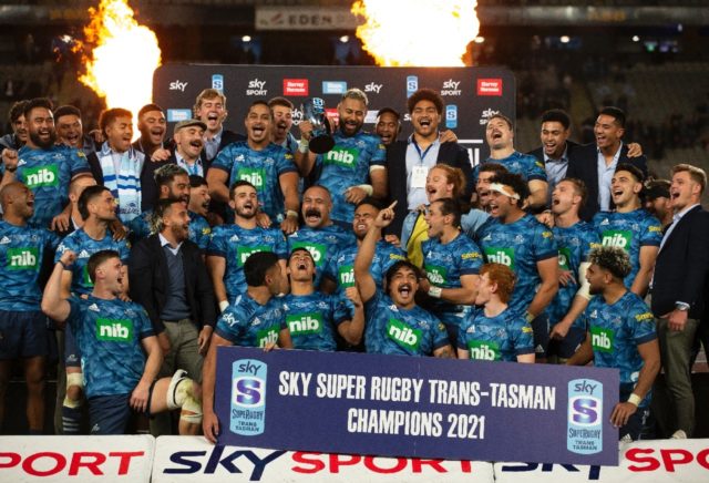 Auckland Blues players celebrate with the Super Rugby Trans-Tasman Trophy after winning th