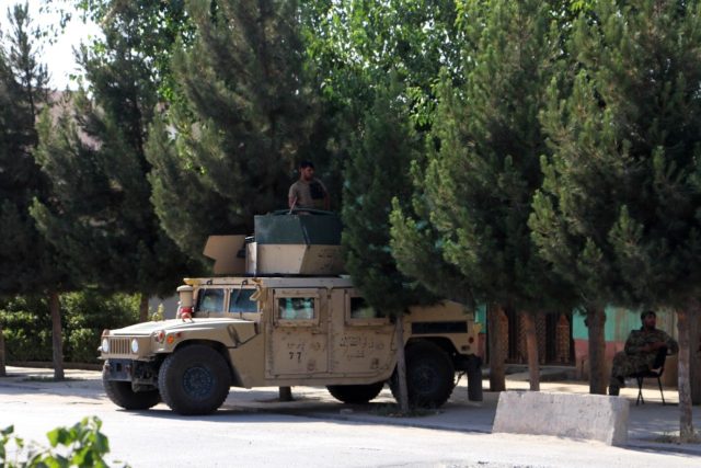 Afghan security forces stand guard on a Humvee vehicle along a roadside in Kunduz on Tuesd