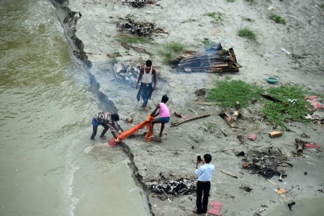 Annual monsoon rains are swelling the Ganges, washing away the sand and revealing corpses