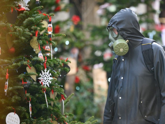 LONDON, ENGLAND - DECEMBER 02: A man wearing full protective clothing and a gasmask walks