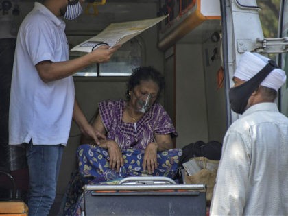 Susheela Singh, 72, whose oxygen level is low waits inside an ambulance outside a COVID-19