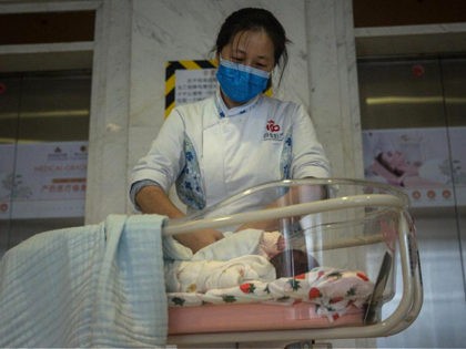 WUHAN, CHINA - MARCH 12: (CHINA OUT) A maternity nurse wears a mask as she cares for a newborn at a Private maternity hospital on March 12, 2020 in Wuhan, Hubei, China. Due to the shortage of medical resources in Wuhan, many pregnant women choose to give birth in private …